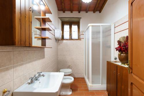 a bathroom with a white sink and a toilet at Infinito in Sinalunga