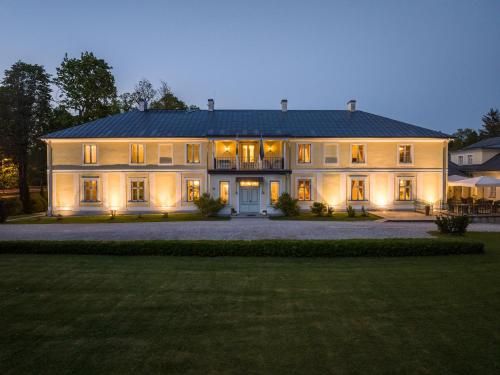 a large white house with its lights on at Padise Manor in Padise