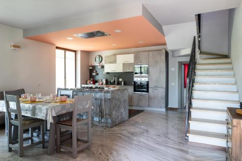 cocina y comedor con mesa y escalera en Villa De Alberti, en Vergiate