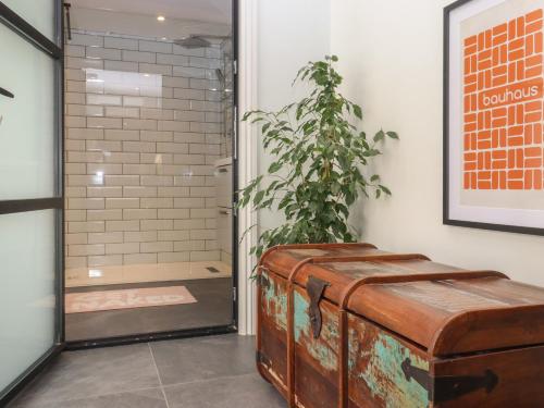 a suitcase sitting in front of a shower with a plant at Artists Hideaway in Battle