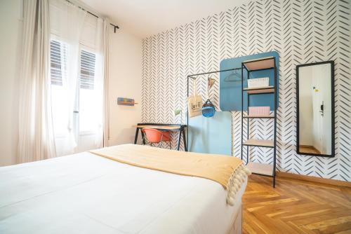 sypialnia z białym łóżkiem i lustrem w obiekcie Live It Madrid Chamberi w Madrycie