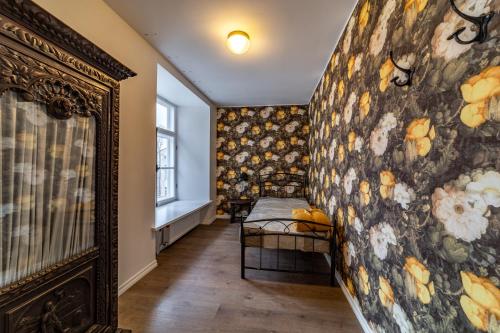 a hallway with a wall covered in floral wallpaper at Roofs of the Old Tallinn Guest House in Tallinn