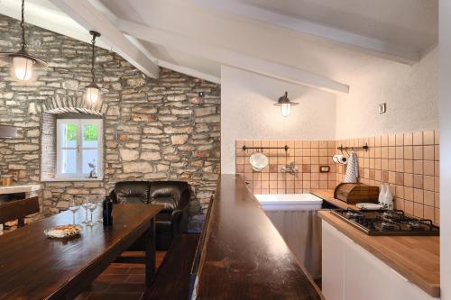 a kitchen with a table and a stone wall at Villa Mala in Umag