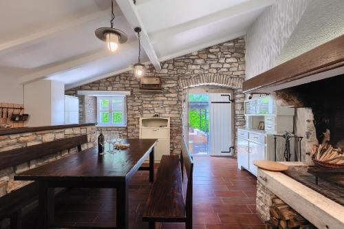 a kitchen with a wooden table and a stone wall at Villa Mala in Umag