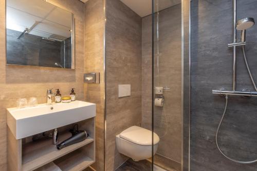 a bathroom with a toilet and a sink and a shower at Fletcher Hotel Restaurant Hellendoorn in Hellendoorn