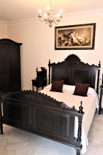 a bedroom with a black bed and a piano at Hostal Ciudad Trigueros in Trigueros