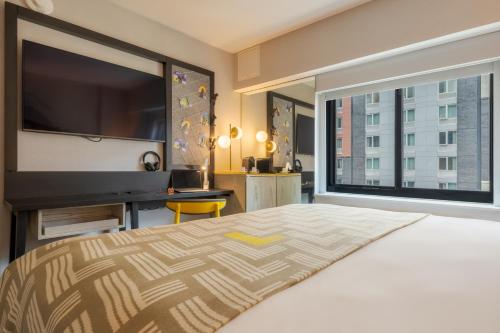 a bedroom with a large bed and a large window at Pestana CR7 Times Square in New York