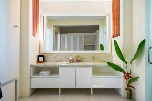 a bathroom with a sink and a mirror at Raaga Samudra Villa in Padangbai