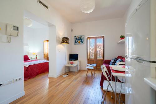 un soggiorno con letto e tavolo in una camera di My City Home - Luminoso apartamento en Puerta del Ángel a Madrid