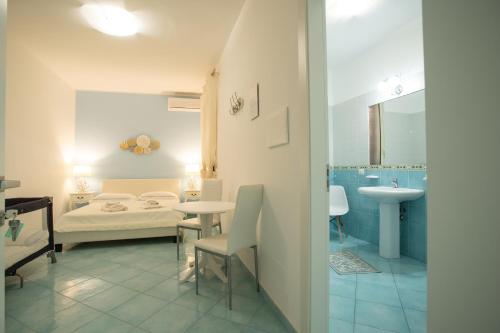 a bathroom with a bed and a sink in a room at Casa di Nonno Gerlando in Lampedusa