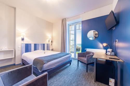 a hotel room with a bed and a desk and chair at Logis Hôtel Ker Mor in Perros-Guirec