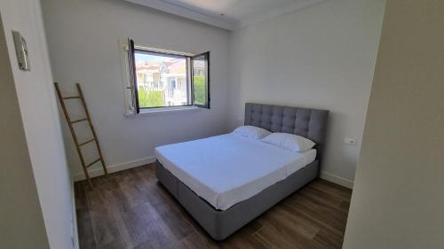a small bedroom with a bed and a window at Lustica Lux in Tivat