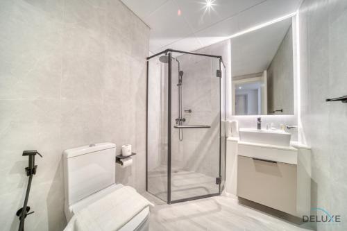 een badkamer met een douche, een toilet en een wastafel bij Graceful Studio at Mesk 1 Midtown Dubai Production City by Deluxe Holiday Homes in Dubai