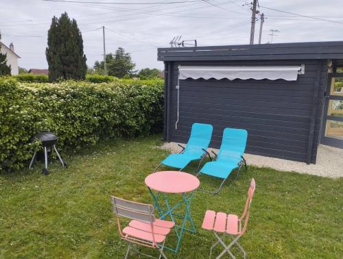 a group of chairs and a table in the yard at Tiny house toute équipée avec jardin in Saint-Florent-sur-Cher