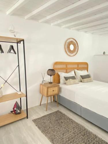 a bedroom with a bed with a table and a mirror at Oculus Mykonos Suite II in Mikonos