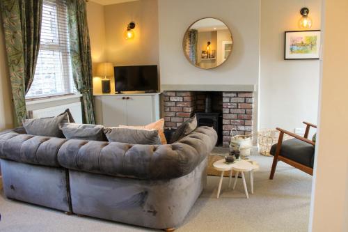a living room with a leather couch and a fireplace at No4 Chapel Row in Bakewell