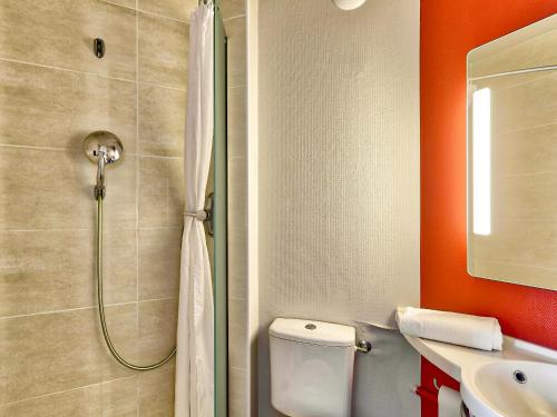 a bathroom with a shower and a toilet and a sink at B&B HOTEL Clermont-Ferrand Gerzat in Gerzat