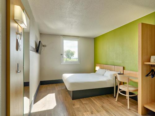 ジェルザにあるB&B HOTEL Clermont-Ferrand Gerzatのベッドルーム1室(ベッド1台、テーブル、窓付)