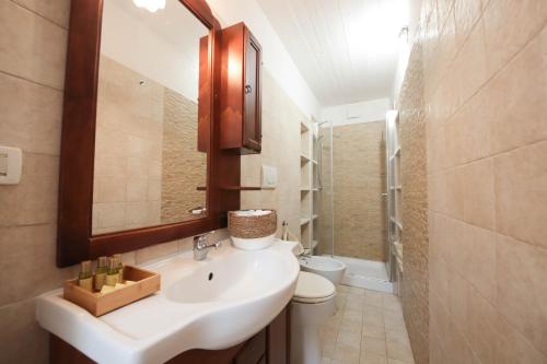 a bathroom with a sink and a toilet and a mirror at Villa Dyria exclusive swimming pool in Monopoli