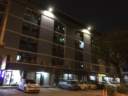 a parking lot in front of a building at night at Goody Hotel in Bangkok