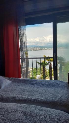 a bedroom with a large window with a view of the ocean at Apartment Ana in Opatija