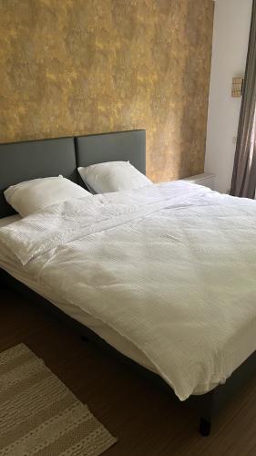 a bed with white sheets and pillows in a bedroom at Vakantiewoning Blijbos in Oostkamp
