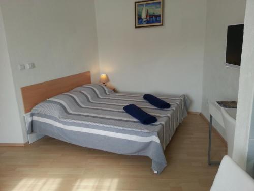 een slaapkamer met een bed met twee blauwe kussens erop bij New Studio Apartments Trlaja in Šibenik