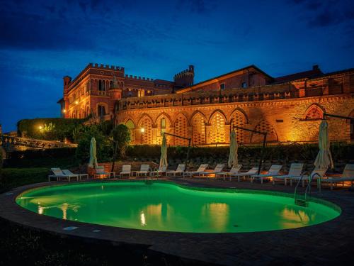 una piscina di fronte a un edificio di notte di Il Castello di San Ruffino a Lari