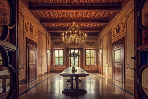 una grande camera con tavolo e lampadario a braccio di Il Castello di San Ruffino a Lari