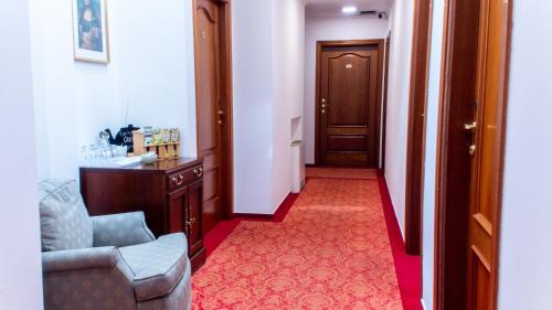 a hallway with a chair and a table and a door at OPERA16 Guestrooms in Budapest