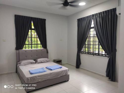 een slaapkamer met een bed en 2 ramen bij NEW 55 Homestay Corner Lot Spacious House in Bukit Bakri Muar in Muar