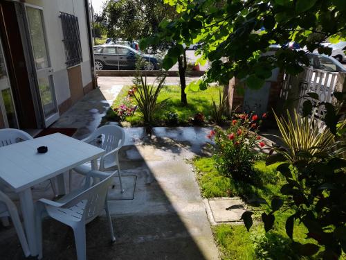 a white table and chairs in a garden at La Casera in Lido di Dante