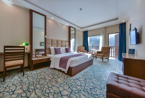 帕哈尔加姆The Chinar Resort & Spa, Pahalgam的带大床和阳台的酒店房间