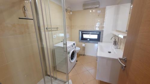 a bathroom with a washing machine and a sink at Apartment Laurus in Portorož