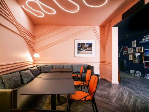 um restaurante com um sofá, mesas e cadeiras em TRIBE Paris Batignolles em Paris