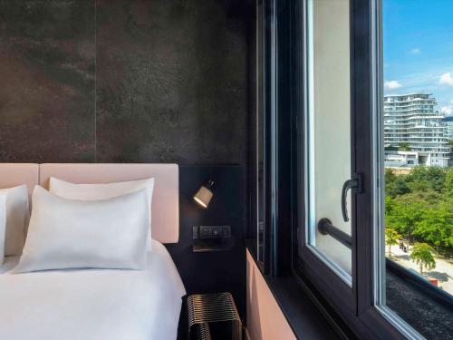 a bedroom with a white bed and a window at TRIBE Paris Batignolles in Paris