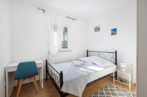 1 dormitorio con 1 cama y 1 silla azul en Apartment Luca, en Vranjic