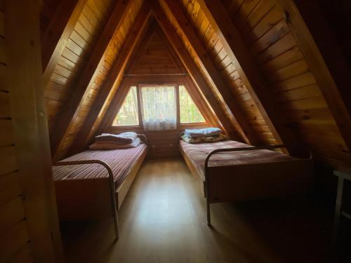 斯蒂格纳Domki Pod Sosnami的小木屋内的小房间设有两张床