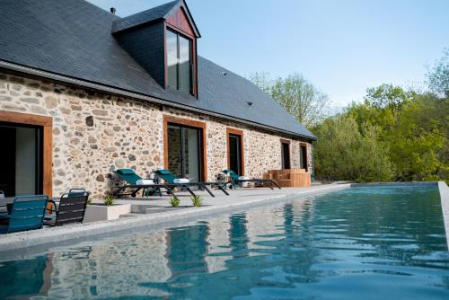 a house with a swimming pool next to a building at Lodge du Hautacam in Ayros-Arbouix