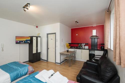 a living room with a black leather couch and a kitchen at Bradford Apartments in Bradford