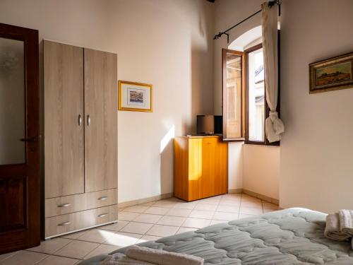 a bedroom with a bed and a cabinet and a window at Casa Pisani 21 in Iglesias