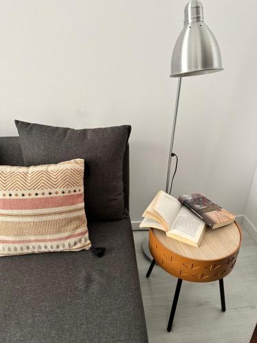 a bed with a lamp and a table with books on it at A Casa do Tio Joaquim in Montemor-o-Novo