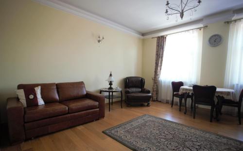 ein Wohnzimmer mit einem Sofa, Stühlen und einem Tisch in der Unterkunft Apartament MGM Janów Podlaski in Janów Podlaski