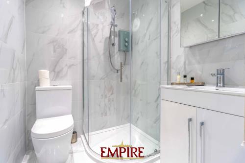 ein weißes Bad mit einer Dusche und einem WC in der Unterkunft Modern 1 Bedroom Apartment 5mins from the NEC! in Birmingham