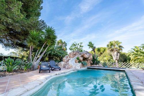 - une piscine dans une cour avec 2 chaises et des arbres dans l'établissement Villa Concha by Indigo, à Benagil