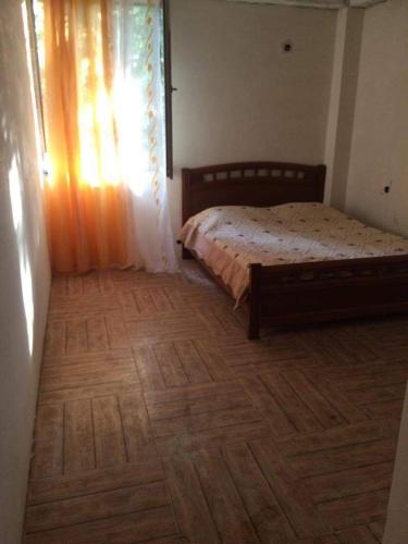 a bedroom with a bed and a wooden floor at Ureki გურიის ქუჩა 47ბ in Ureki