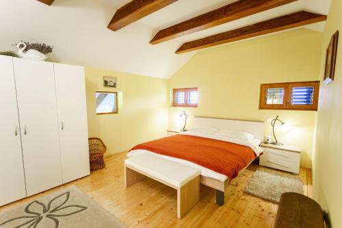 ein Schlafzimmer mit einem großen Bett in einem Zimmer mit Holzböden in der Unterkunft Kuća za odmor Zeleni breg in Krapina
