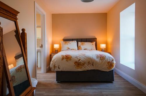 BallylongfordにあるCarrig Island Lodgeのベッドルーム(ベッド1台、鏡付)