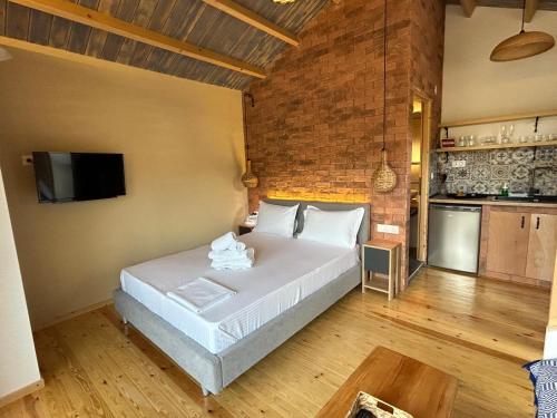 a bedroom with a bed and a brick wall at kartalia wooden studios in Porto Koufo
