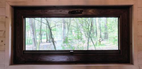 a window with a view of a forest at Kujanki - domki z widokiem na jezioro in Zakrzewo